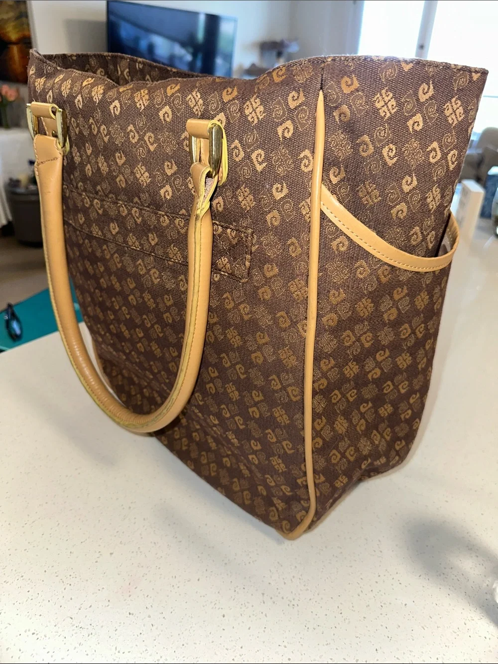 This is a brown Pierre Cardin monogram logo tote bag with beige leather handles.